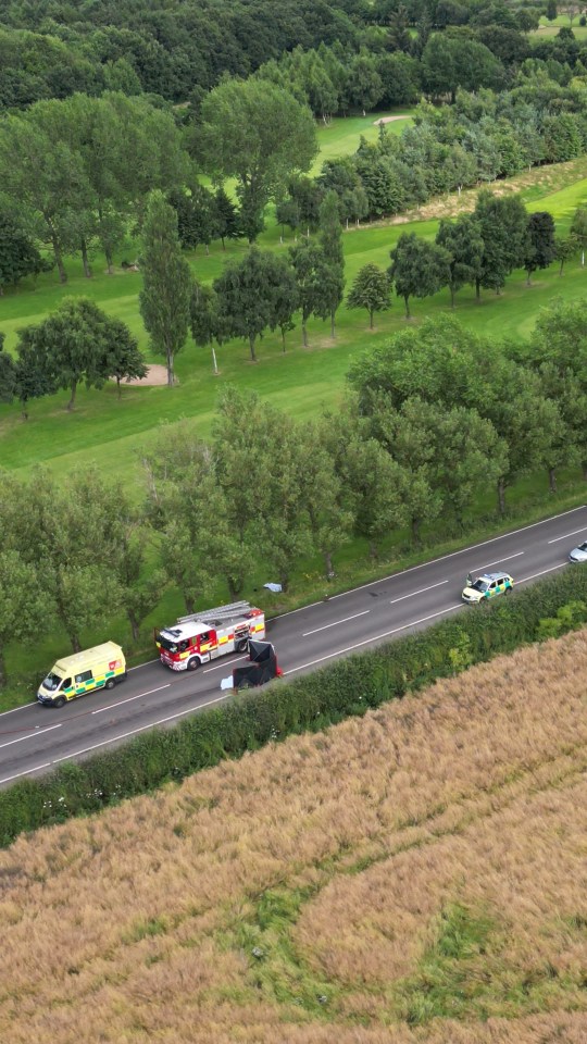 an ambulance is driving down a road next to a field