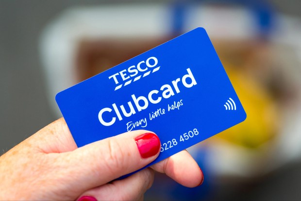 a person holding a blue tesco clubcard in their hand