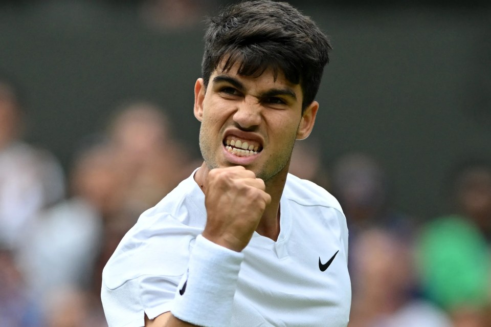 a man wearing a white nike shirt with his fist in the air