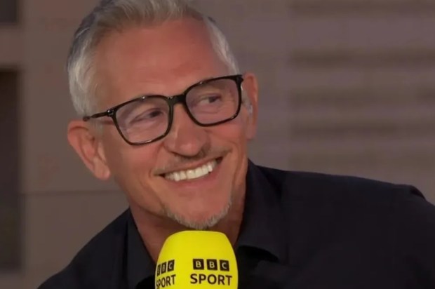 a man wearing glasses and a yellow bbc sport microphone