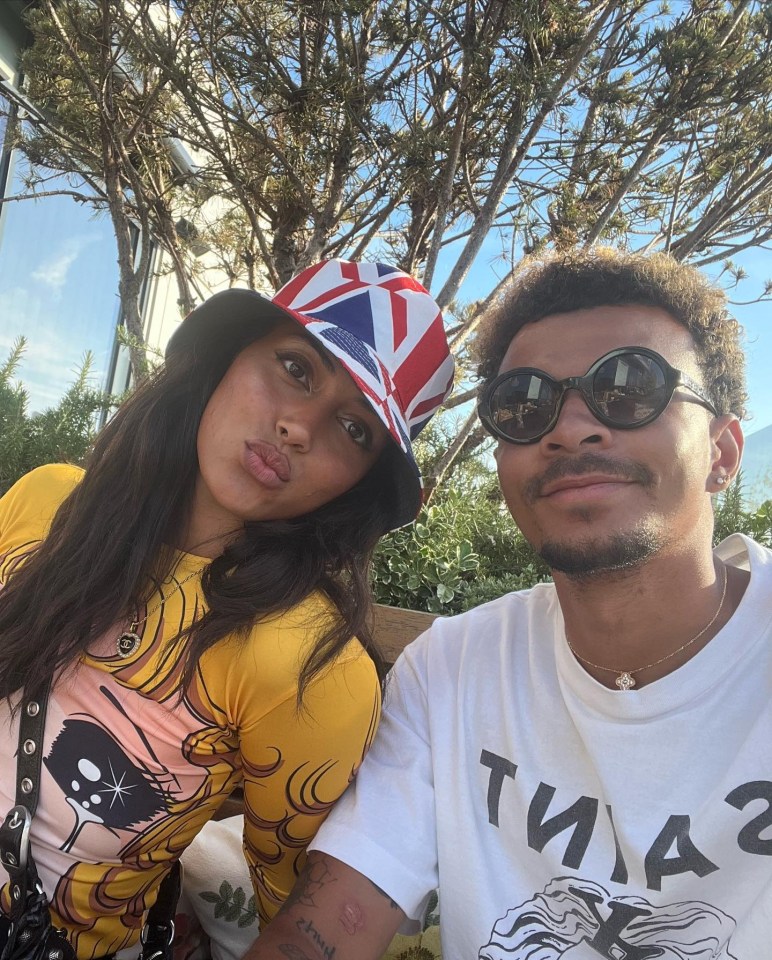 a man and a woman are posing for a picture and the woman is wearing a bucket hat