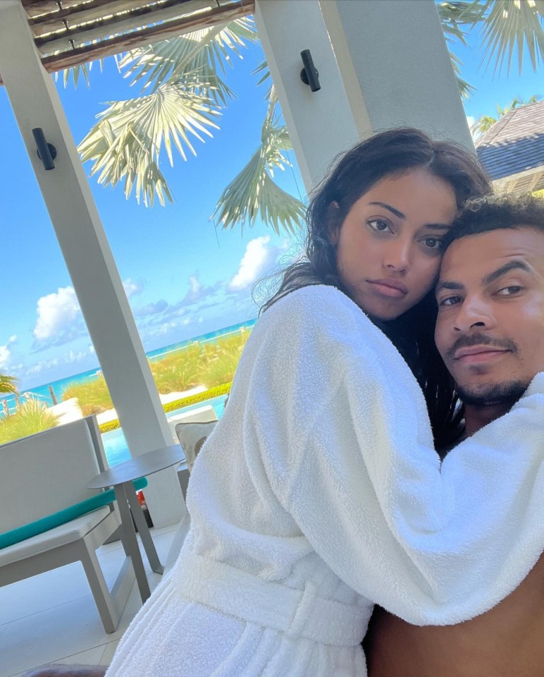 a man and a woman are posing for a picture and the woman is wearing a white robe