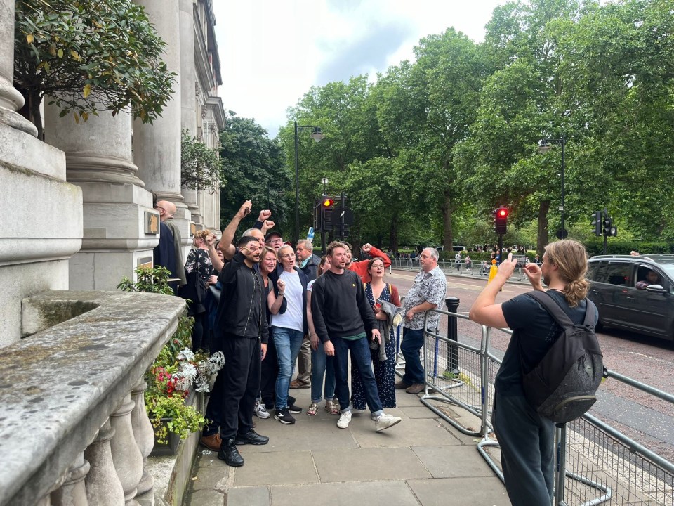 a man taking a picture of a group of people on a sidewalk