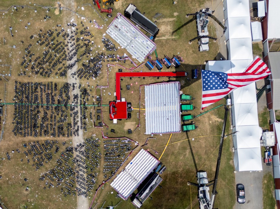 a large american flag is flying in the middle of a field