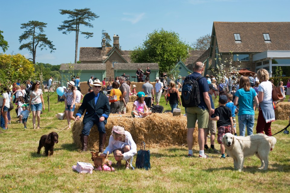 a group of people are gathered in a field with hay bales