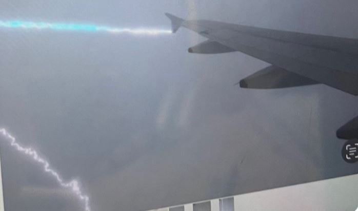 a lightning bolt is coming from the wing of an airplane