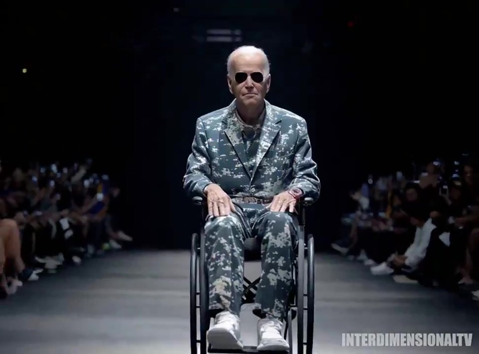 Joe Biden sits in a wheelchair and models a camo-suit