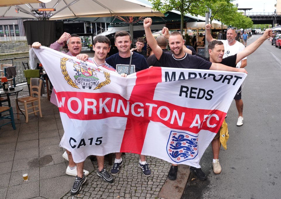 England fans on Friedrichstrasse with a flag next to the river Spree in Berlin