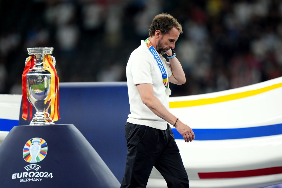 a man stands in front of a euro2024 trophy