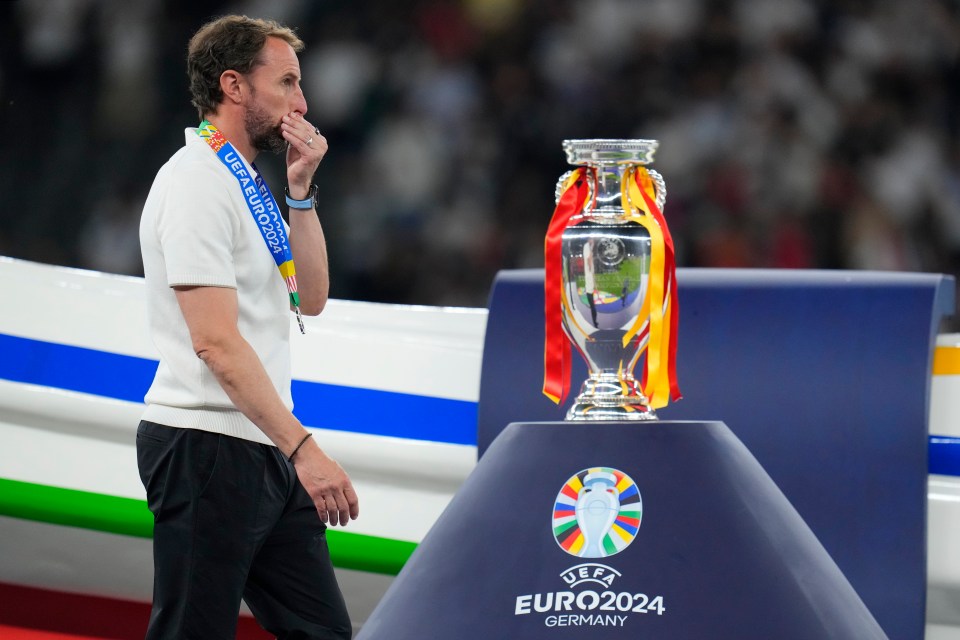 a man stands in front of a trophy that says euro2024 germany