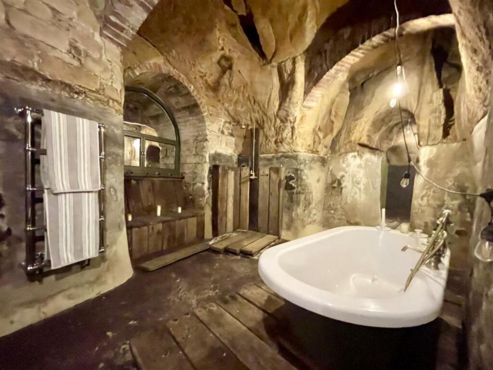 It offers three bathrooms including one in a vaulted cave with mysterious faces