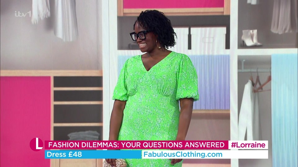 a woman in a green dress is on a television show