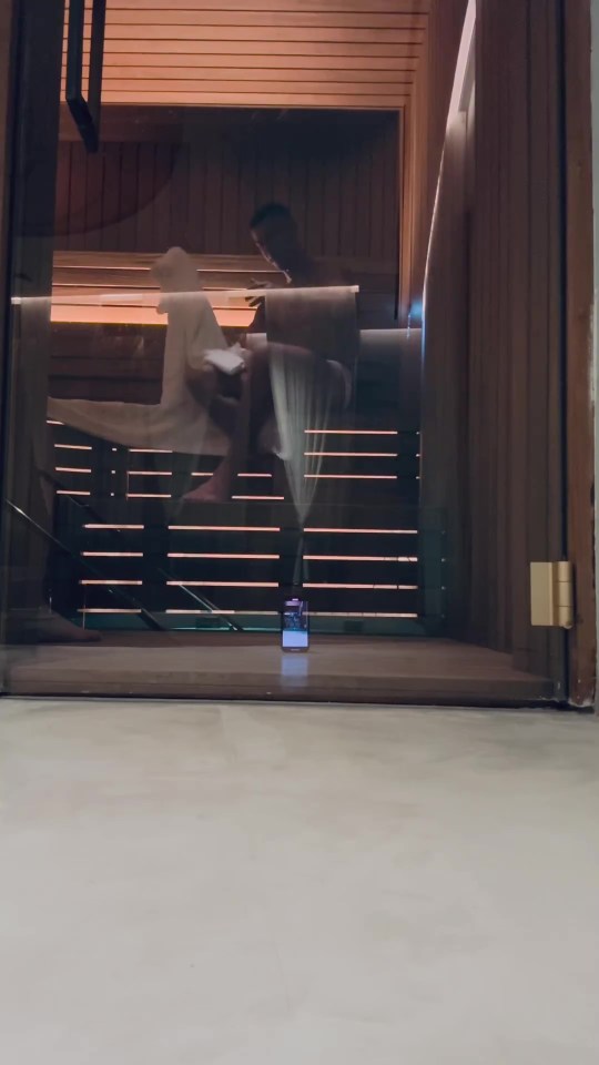 a reflection of a person sitting in a chair in a sauna