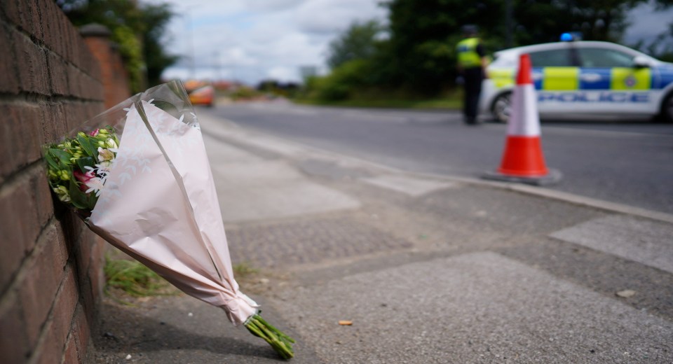 a bouquet of flowers sits on the sidewalk in front of a police car