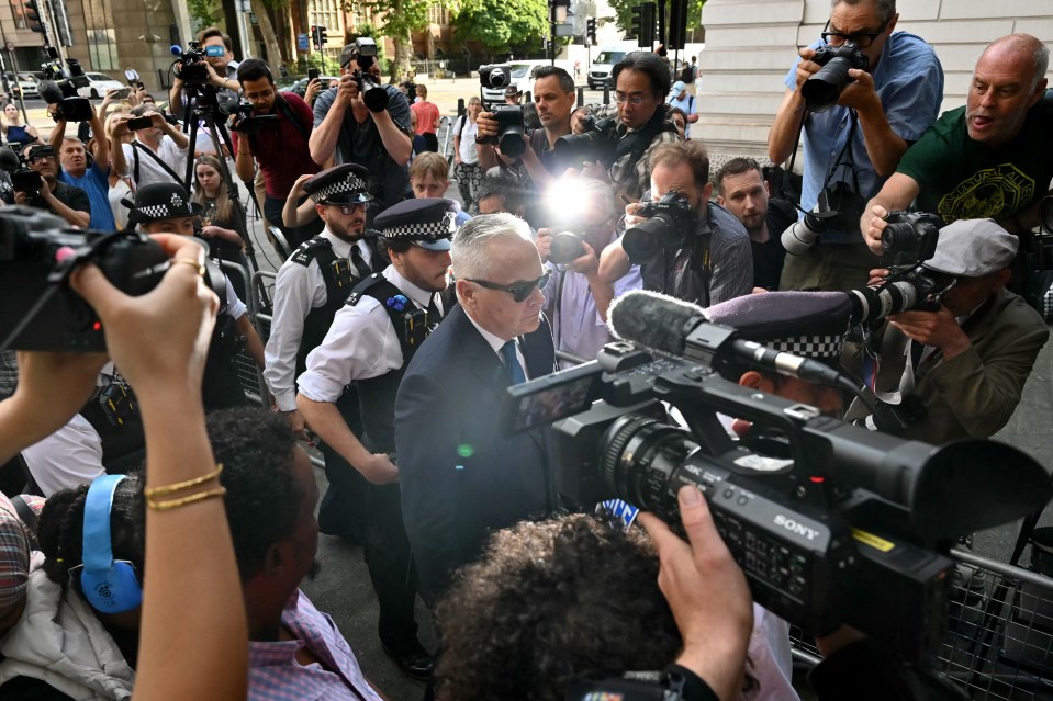 He was surrounded by police as he made his way through the scrum outside