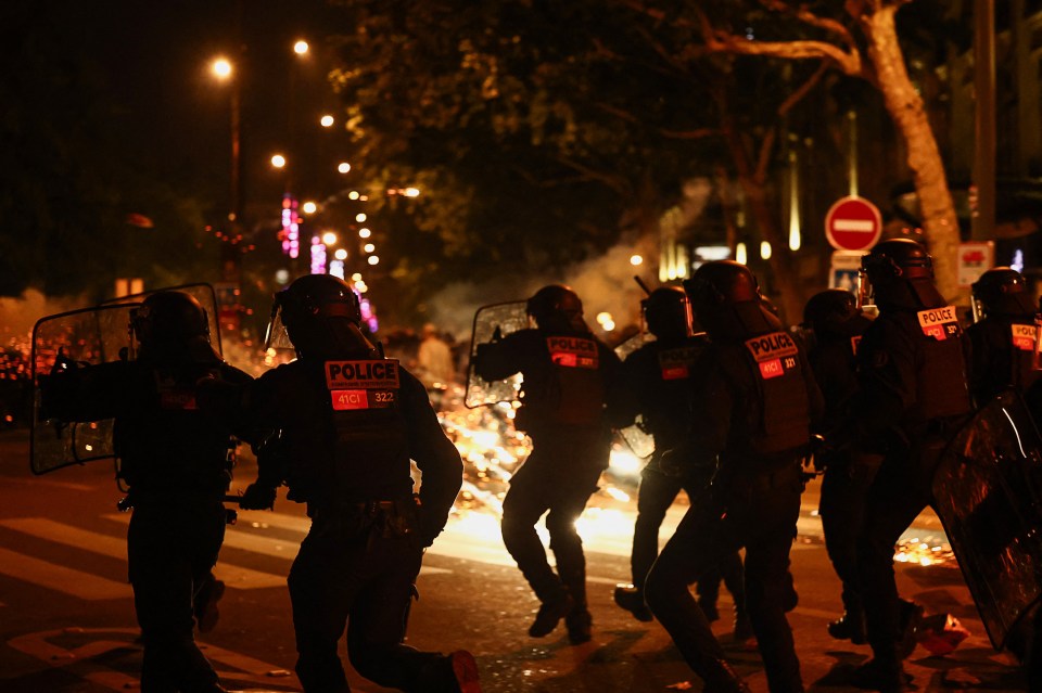 French riot police run during clashes with demonstrators in Paris