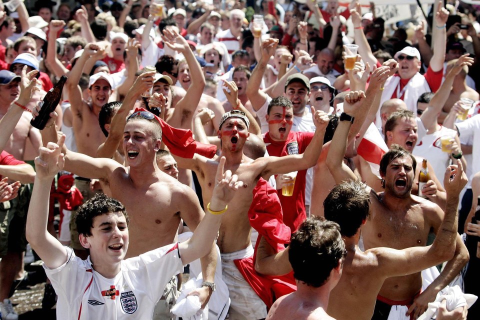 a crowd of people cheering with one wearing a shirt that says england