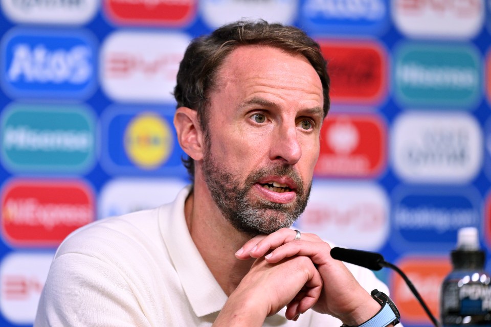 a man sitting in front of a microphone with his hands folded