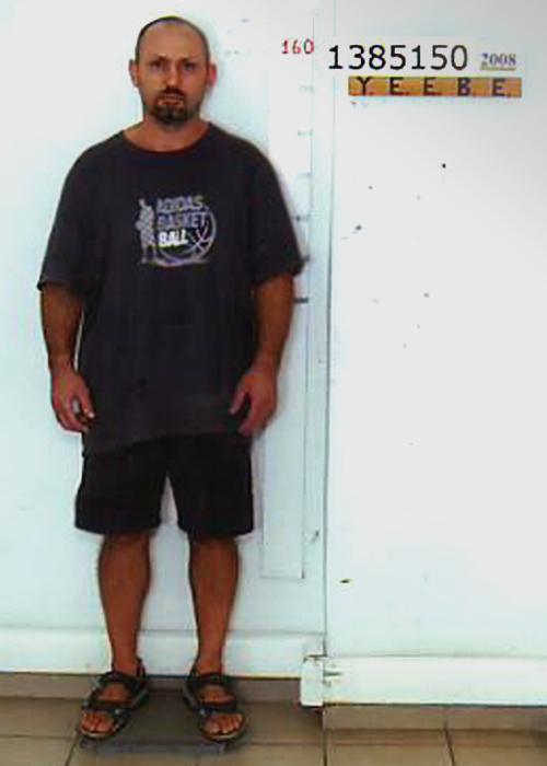 a man wearing an adidas basketball shirt stands in front of a white wall