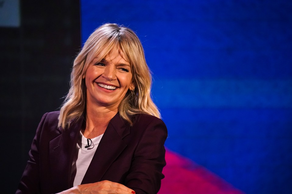 a woman wearing a purple jacket and a white shirt is smiling