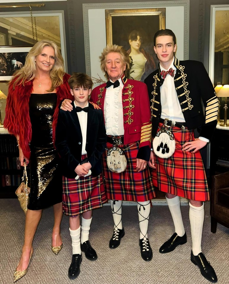 a man in a kilt poses for a picture with his family