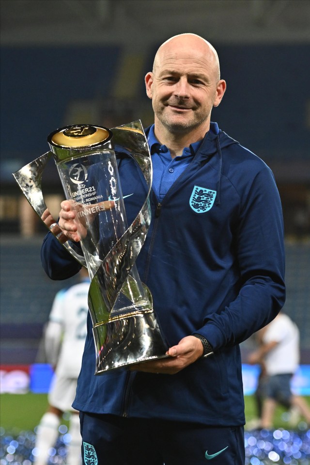 a man in a blue nike jacket holds a trophy