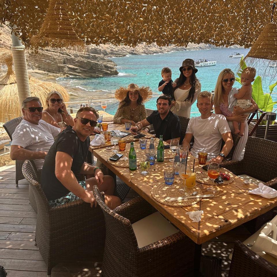 a group of people are sitting around a table with bottles of water on it