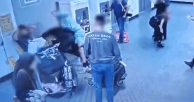 A struggle breaks out between three police officers and two men during the second clip