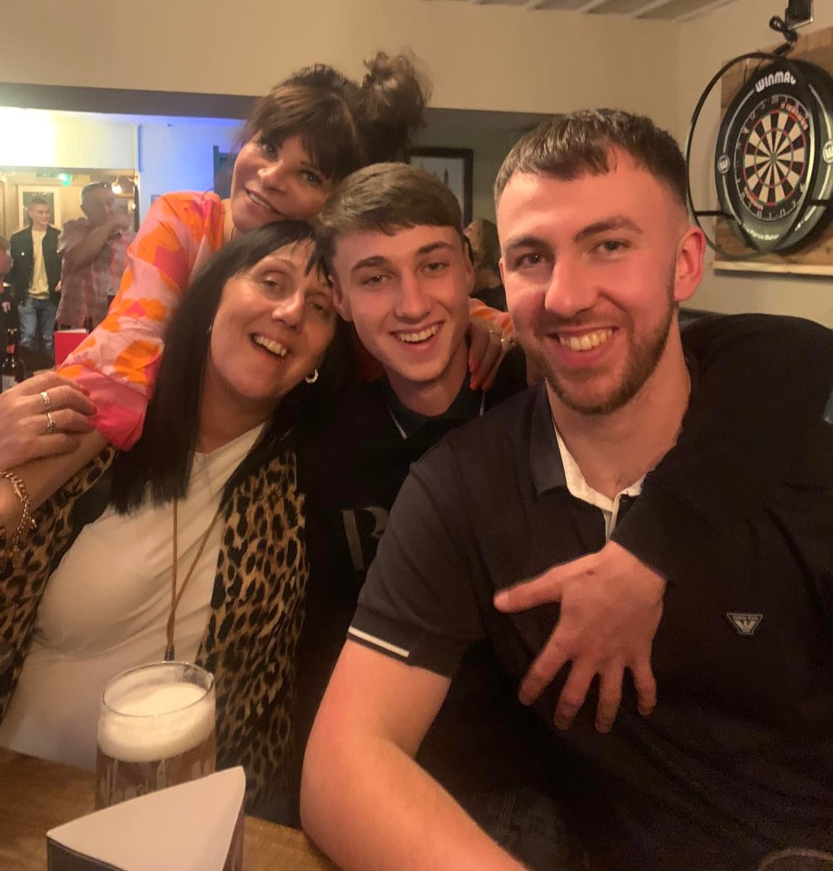 a group of people posing for a picture with a dart board in the background