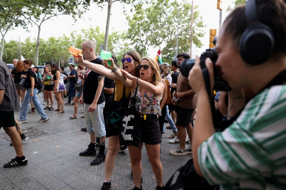 Protesters shoot water from water guns at tourists during a protest against mass tourism in Barcelona, Spain, July 6, 2024. The Catalan capital received more than 12 million tourists in 2023 and expects more in 2024. REUTERS/Bruna Casas