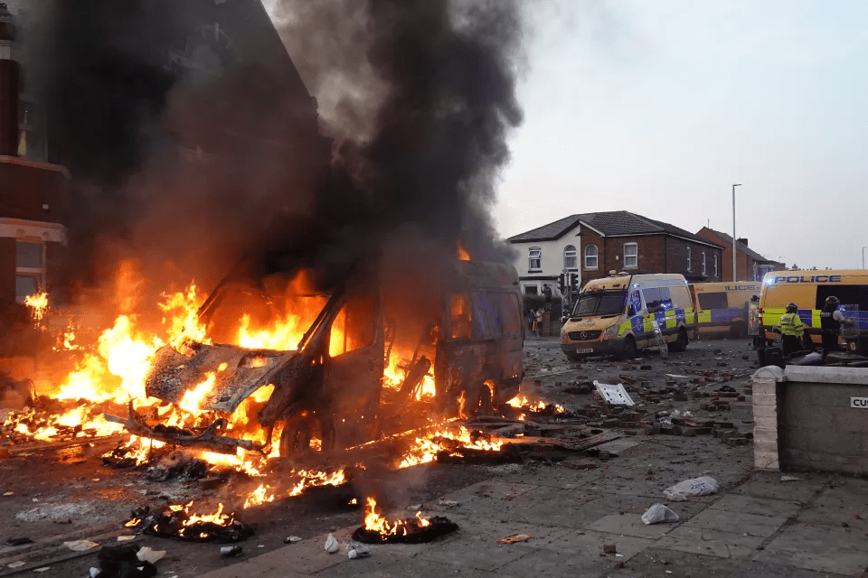 The charred remains of a police vehicle after rioters set it ablaze