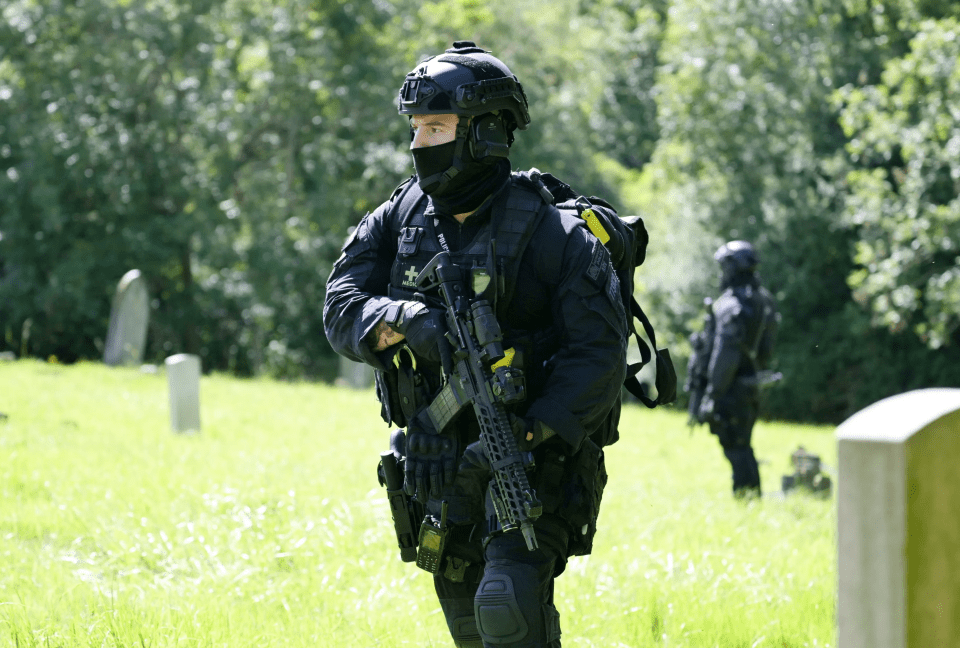 Armed police searching Lavender Hill Cemetery in Enfield