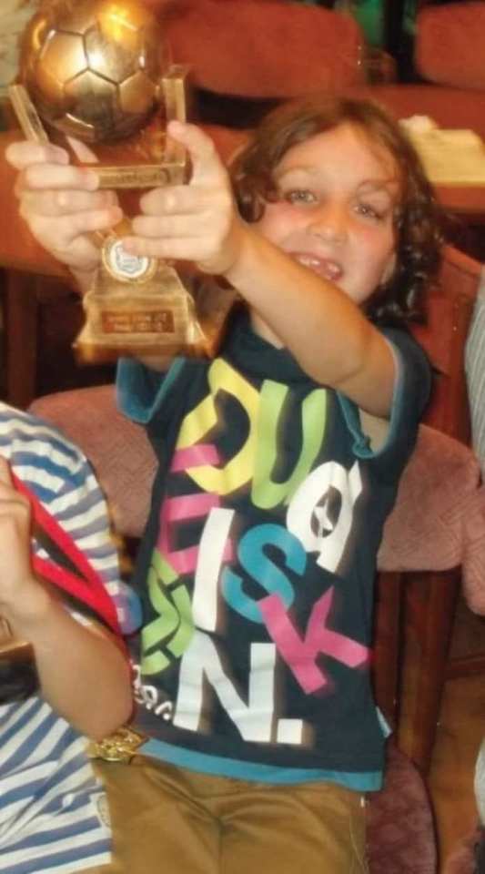 A young Jay posing with a football trophy