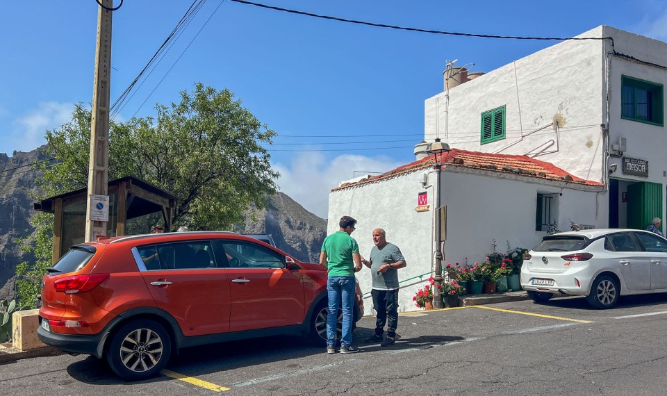 two men are standing in front of a building with a sign that says ' ayuntamiento ' on it