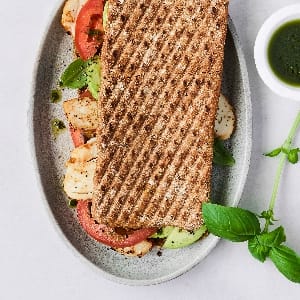 The Joe and the Juice Club sandwich is bread filled with vegan pesto, tomato, chicken and avocado