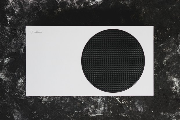 a white xbox is sitting on a black surface