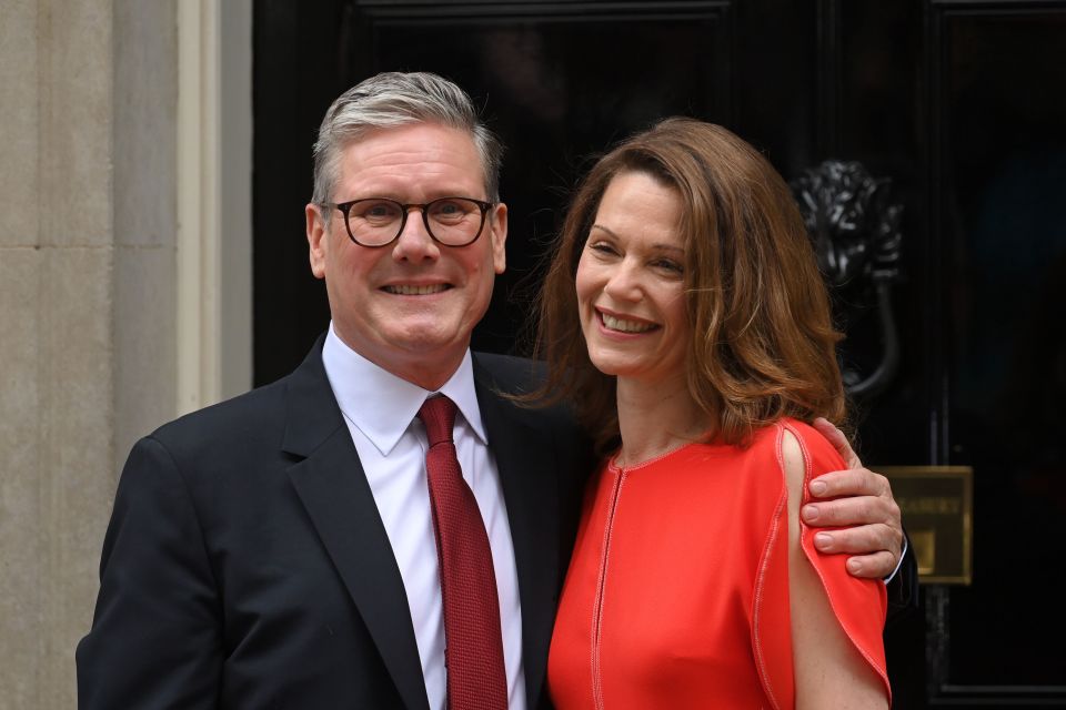 Sir Keir Starmer and his wife Lady Victoria pose for pictures outside the Number 10 door