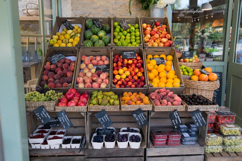 a variety of fruits and vegetables are on display outside of a store