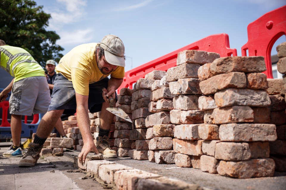 Kingswood Homes workers rebuild a wall