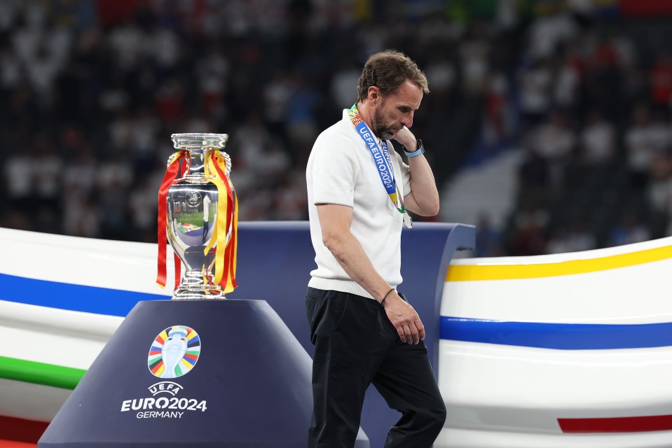 a man stands in front of a trophy that says euro2024 germany