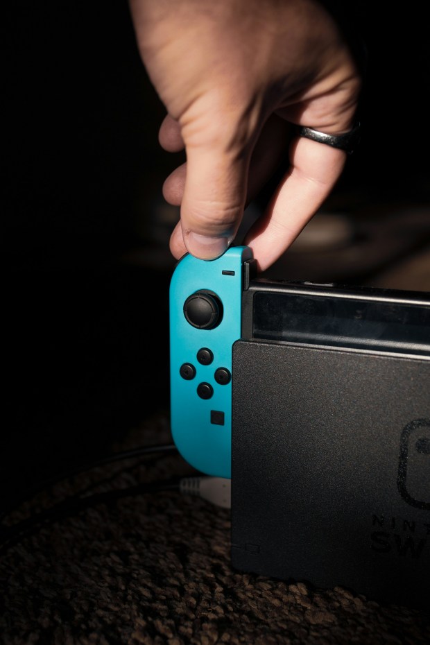 a person is holding a blue nintendo switch controller