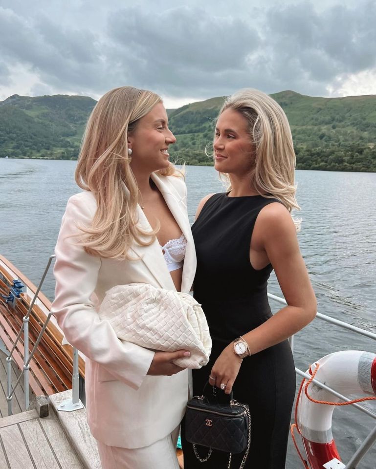 two women standing next to each other with one holding a chanel bag