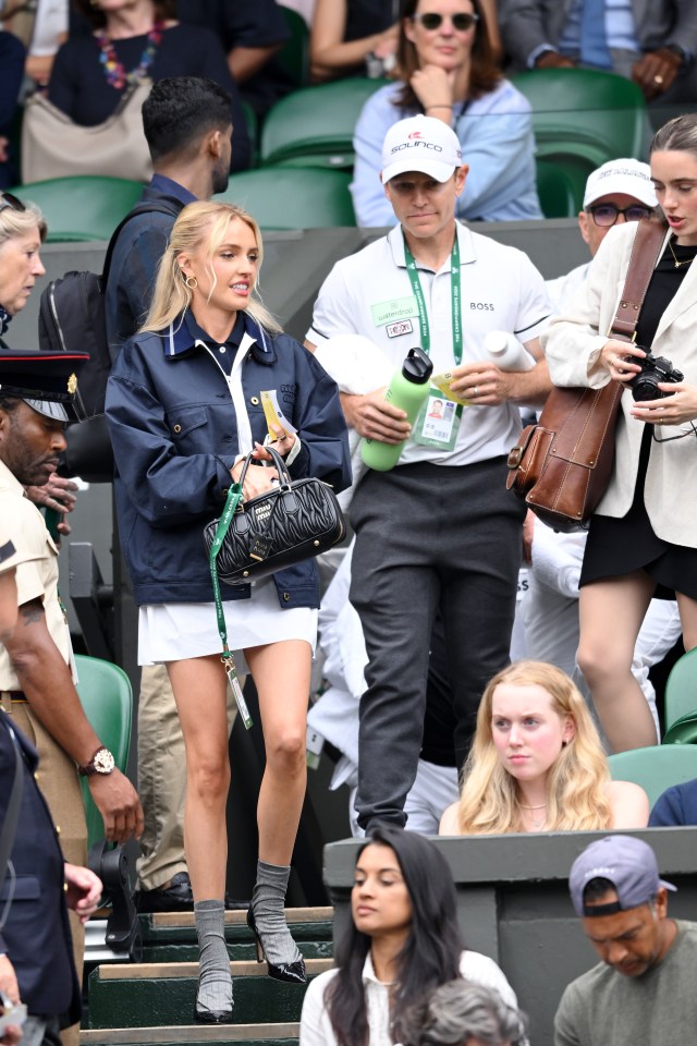 She rocked a navy jacket over a white dress