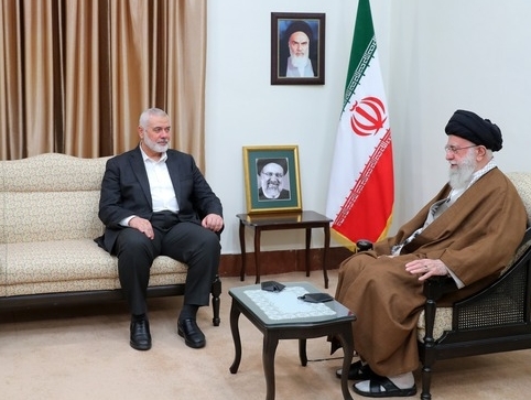 two men are sitting in front of an iranian flag