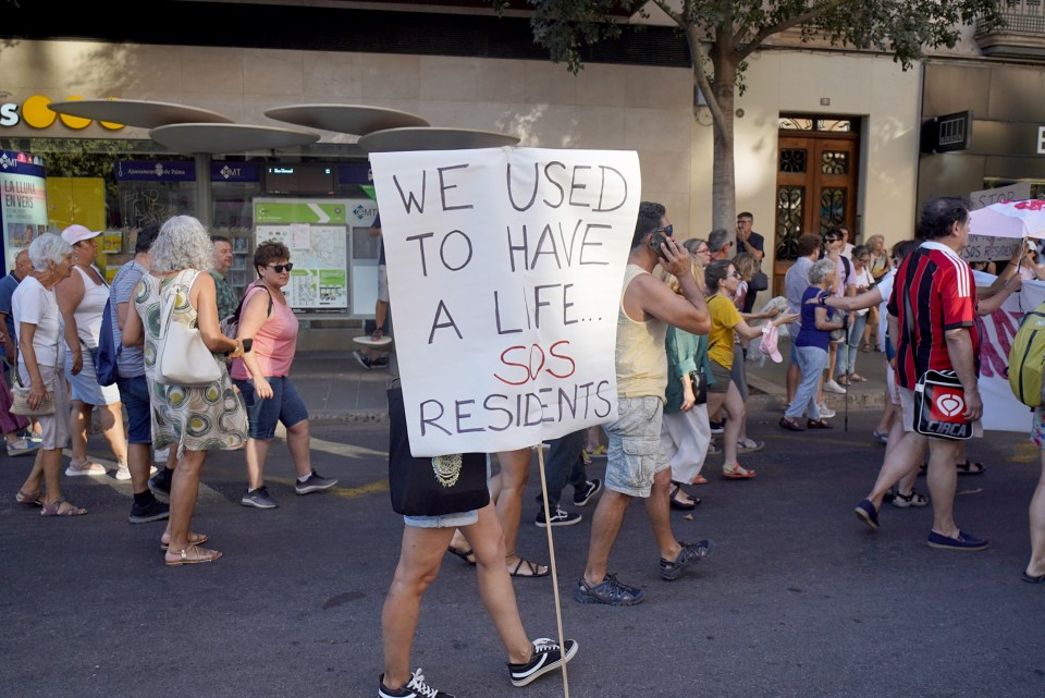 Another anti-tourist sign reads 'WE USED TO HAVE A LIFE... SOS RESIDENTS'