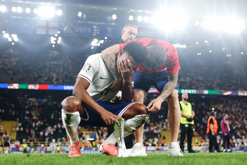 two soccer players on a field with uefa in the background