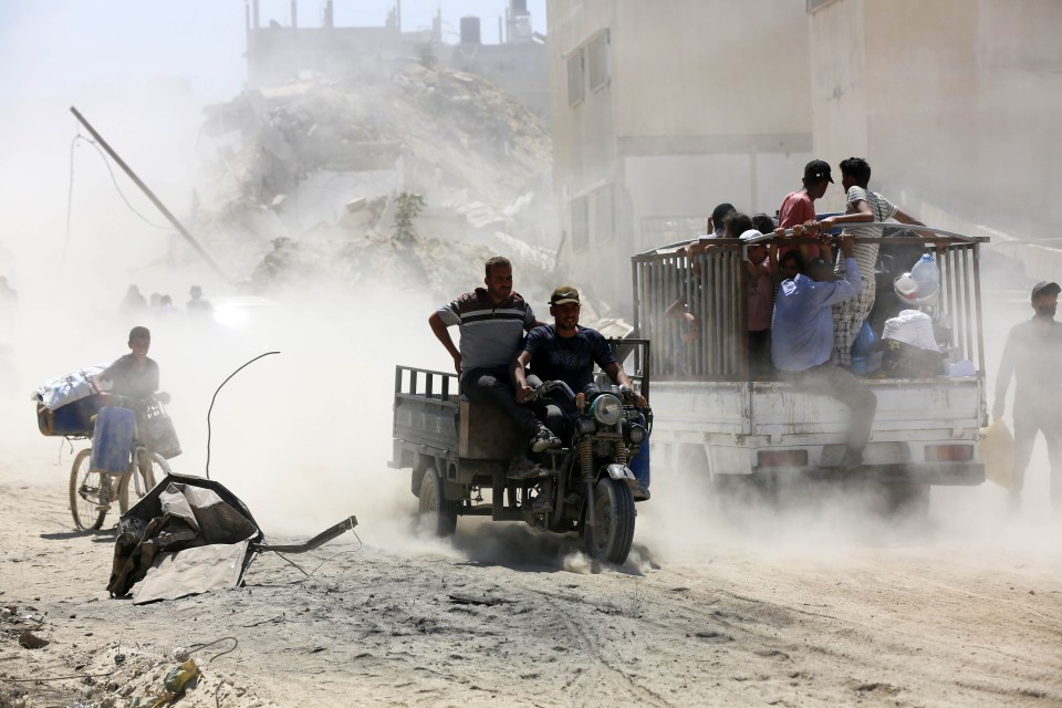 a group of people are riding a motorcycle on a dirt road