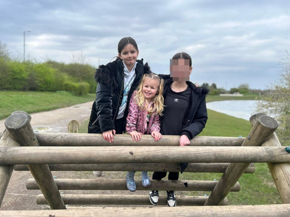 three girls are posing for a picture with one wearing an adidas jacket