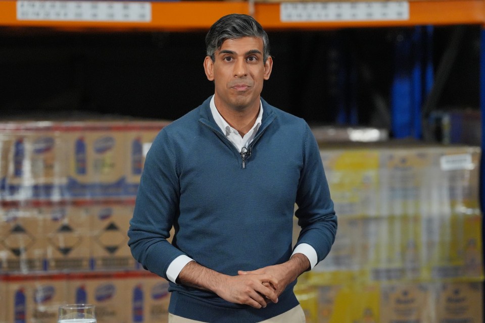 a man in a blue sweater stands in front of a stack of boxes with the word tide on them