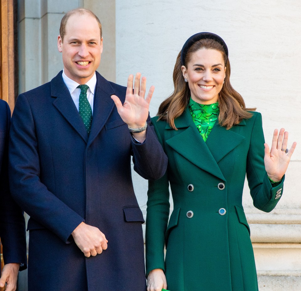 a man in a suit and tie and a woman in a green coat waving